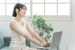 家のリビングでパソコンを使う女性