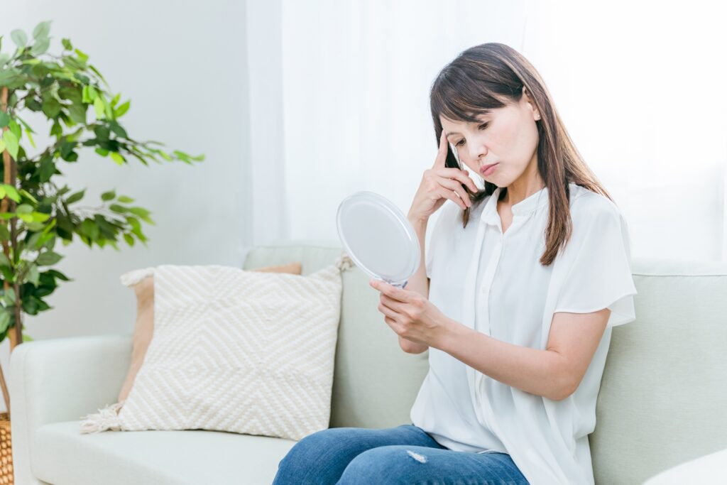 ソファに座る中高年女性（困る）